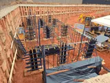 Fundação de obra escavada, com formas e armaduras de aço montadas.