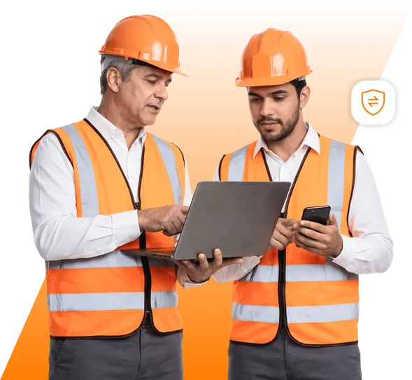 Equipe com capacete e colete laranja ao redor de um notebook